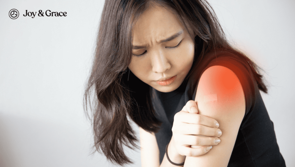 A woman experiencing shoulder pain, possibly resulting from a vaccine or a normal physiological condition.