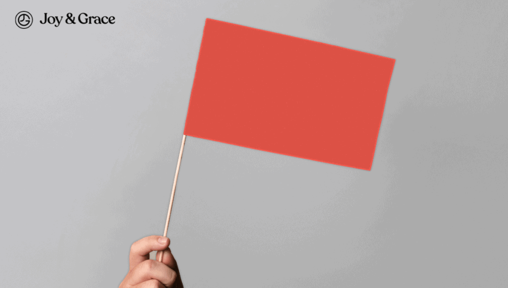 A person holding up a red flag on a gray background, displaying signs of shoulder pain.