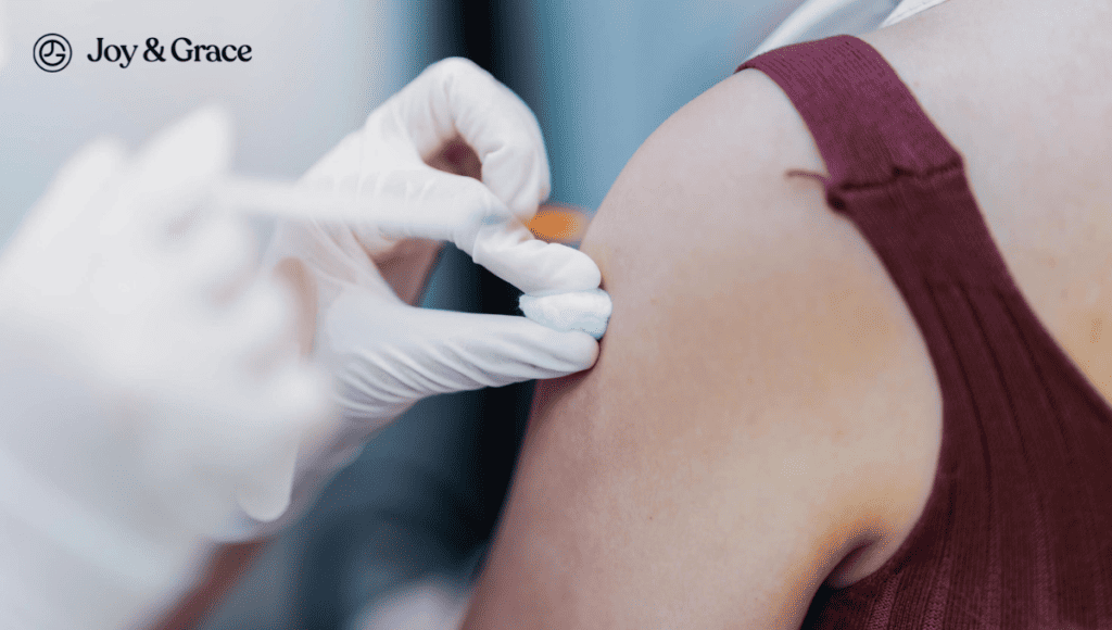 A woman is getting a vaccine on her arm, experiencing a sharp pain as the needle hits a nerve.