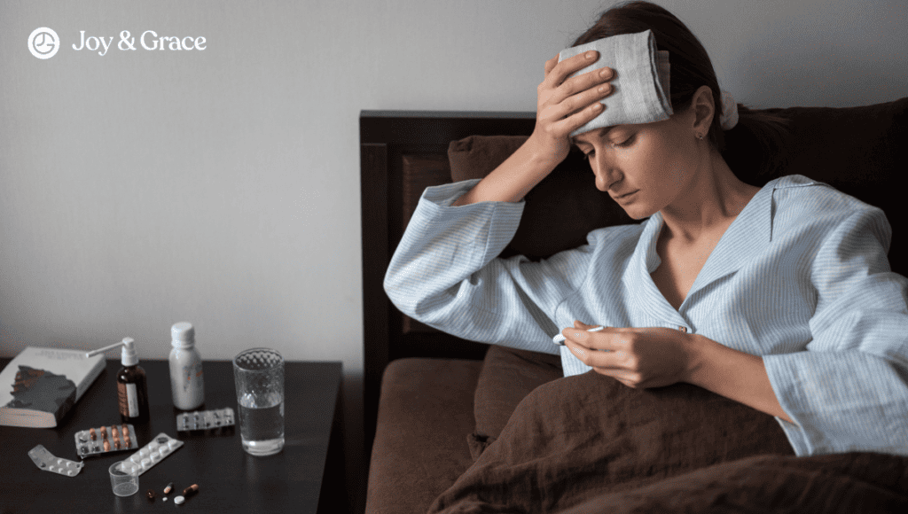 A woman connected to her shoulder pain and cough while laying in bed with pills on her head.