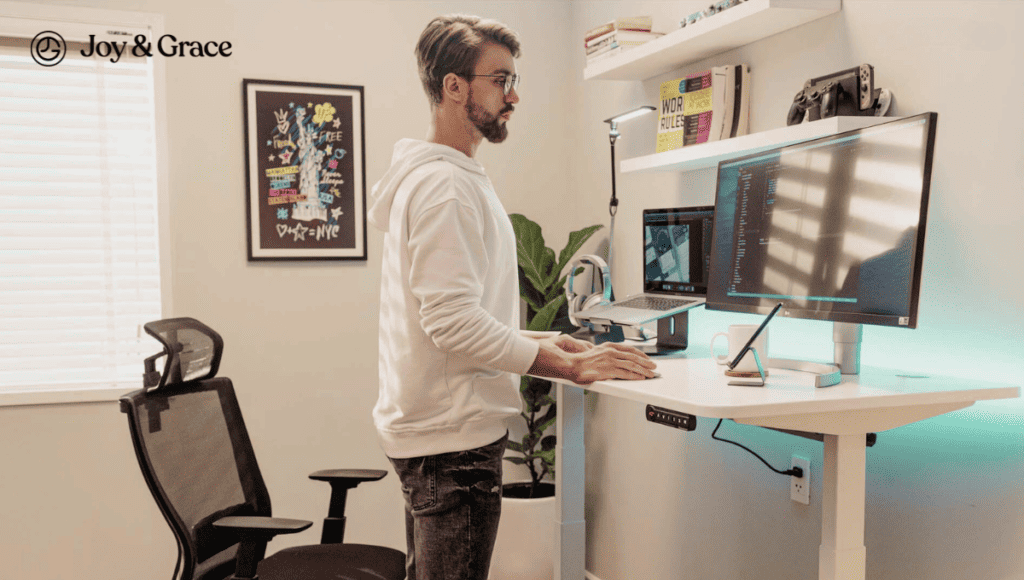 A man experiencing neck pain while working at a standing desk in his home office.